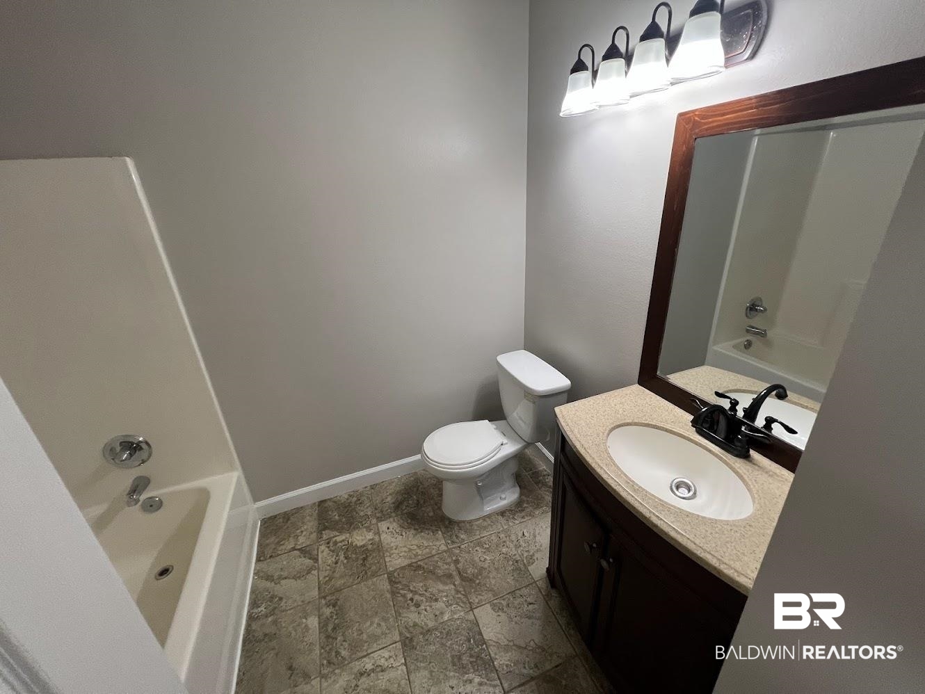 266 Ridgewood Drive Daphne, AL 36526 - Photo 19 of 34 Bathroom featuring a white tub and shower combination, a toilet, and a vanity with a light-colored countertop