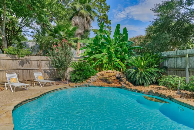 a view of backyard with swimming pool and outdoor seating