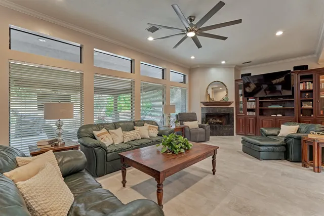 a living room with furniture a fireplace and a large window