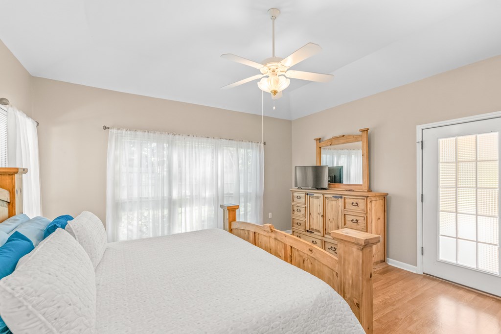 225 Los Cedros Loop Kerrville, TX 78028 - Photo 8 of 27 a bedroom with a bed and a chandelier