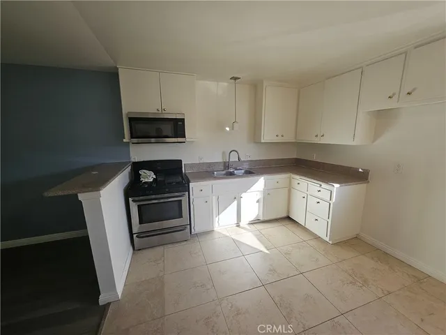 a kitchen with a stove a sink and a microwave