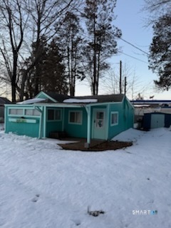 a view of a house with a yard and a large tree