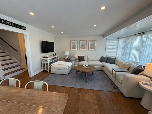 a living room with furniture wooden floor and a flat screen tv