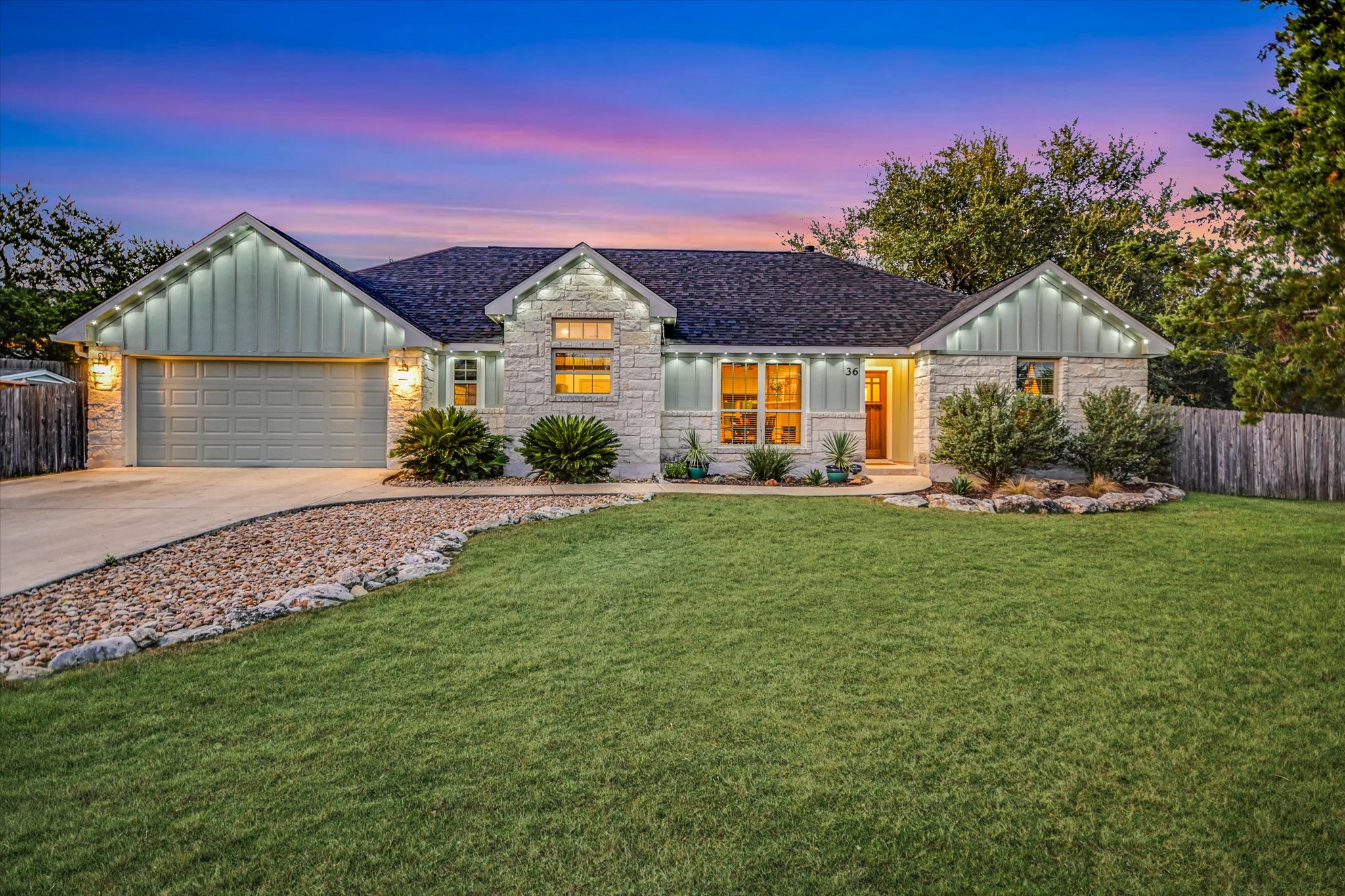 36 Ridgewood Circle Wimberley, TX 78676 - Photo 4 of 30 A well-manicured green lawn sweeps up to this stone and siding single-story residence.