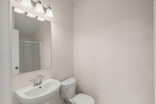a bathroom with a sink mirror and toilet