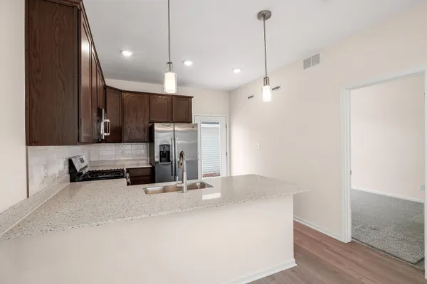 a kitchen with stainless steel appliances a refrigerator sink and microwave