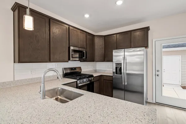 a kitchen with granite countertop a refrigerator and a sink
