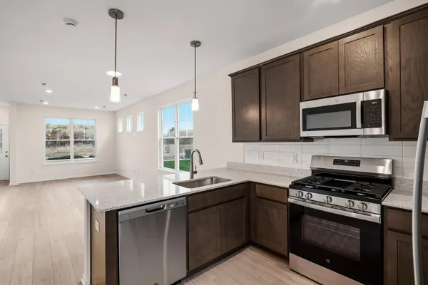 a kitchen with stainless steel appliances a stove sink microwave and cabinets