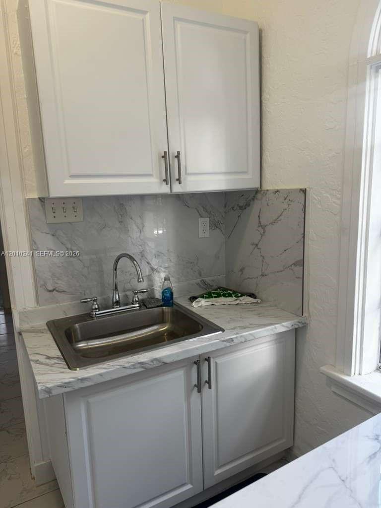 5629 Southwest 7th Street Miami, FL 33144 - Photo 14 of 15 a kitchen with sink a microwave and cabinets