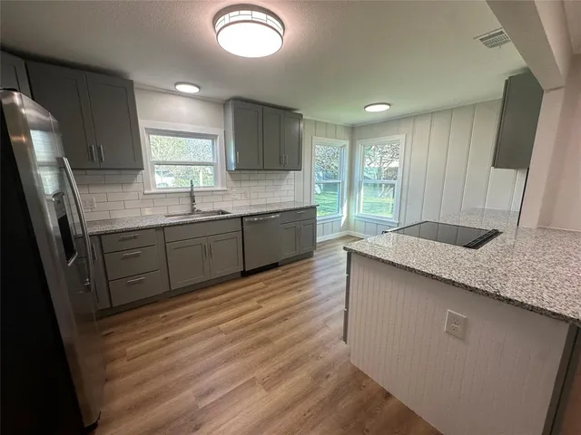 a kitchen with stainless steel appliances granite countertop a sink stove and refrigerator