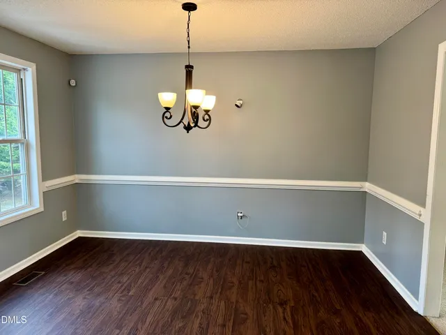 a view of a room with a hardwood floor and a window
