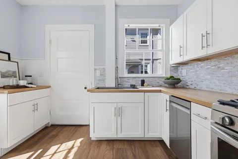 a kitchen with granite countertop white cabinets and white appliances