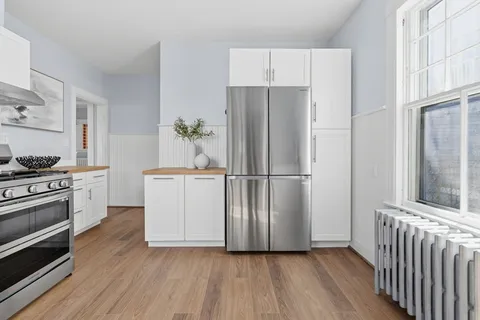 a kitchen with a refrigerator stove and white cabinets