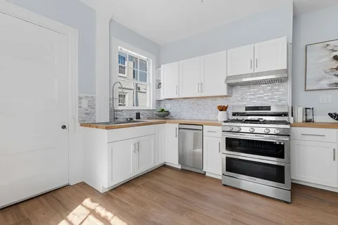 a kitchen with granite countertop white cabinets and white appliances