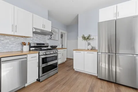 a kitchen with a refrigerator stove and white cabinets