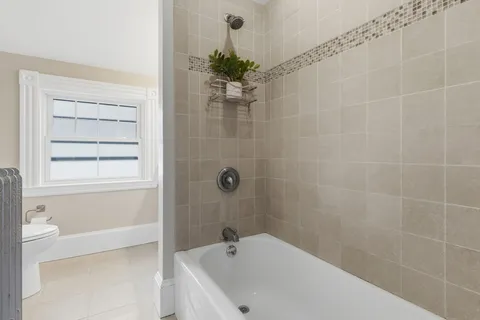 a bathroom with a white bath tub a shower and a sink