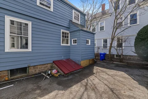 a backyard of a house with barbeque oven table and chairs