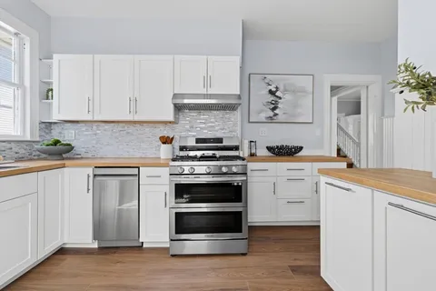 a kitchen with white cabinets and stainless steel appliances