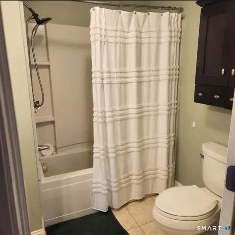 a bathroom with a toilet and a shower curtain