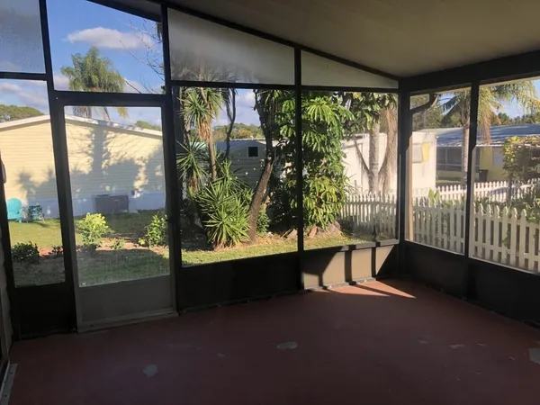 a living room with a large window and yard from a balcony