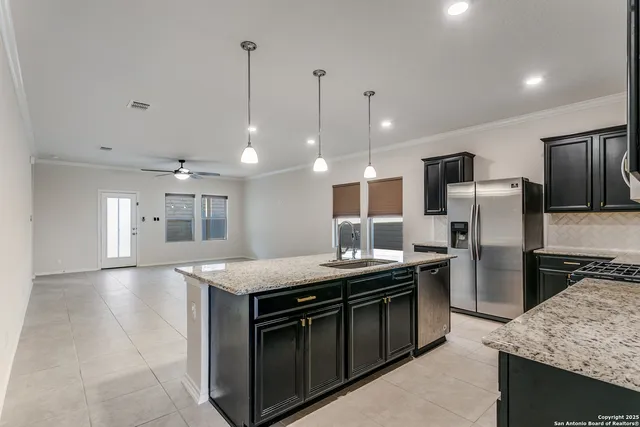 a kitchen with kitchen island a sink stainless steel appliances and cabinets