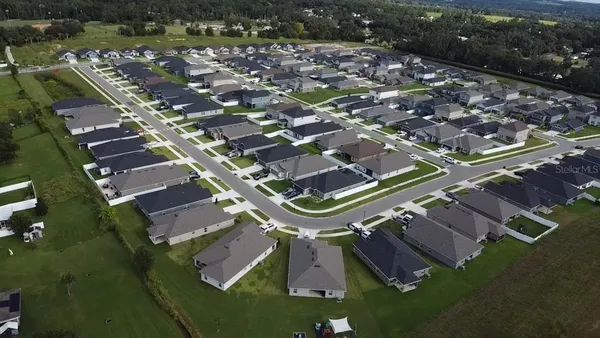 an aerial view of a residential houses with outdoor space and swimming pool