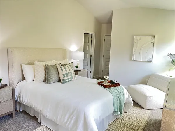 a bedroom with bed a lamp and a couch