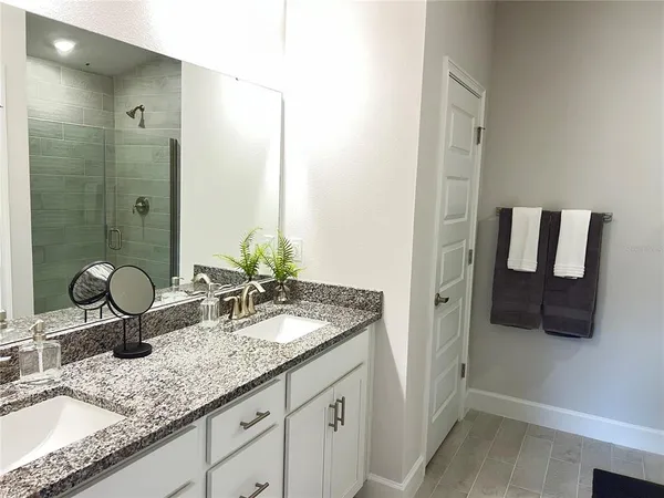 a bathroom with a granite countertop sink and a mirror