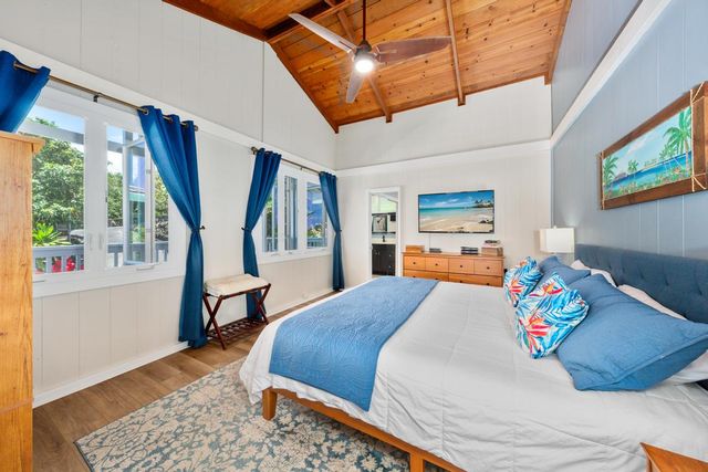 a bedroom with a bed a dresser and a large window