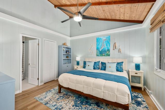 a bedroom with a bed lamps and wooden floor