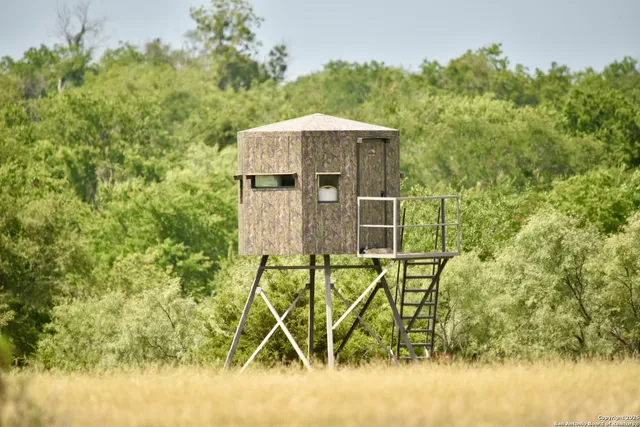 a roof deck with table and chairs under an umbrella