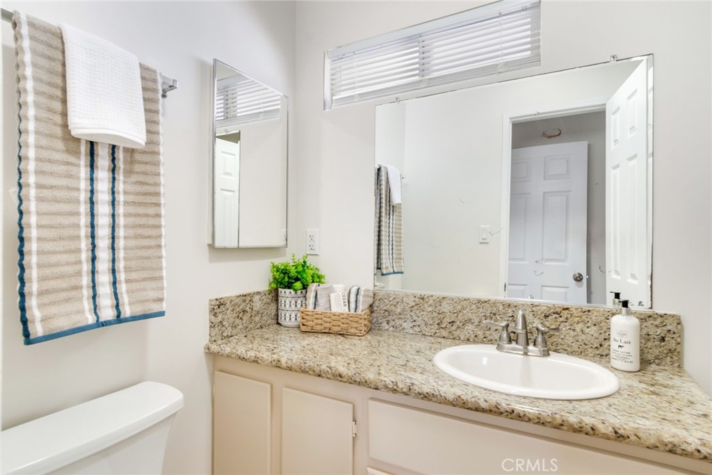 8955 Holly Lane Riverside, CA 92503 - Photo 16 of 32 a bathroom with a granite countertop sink and a mirror with toilet