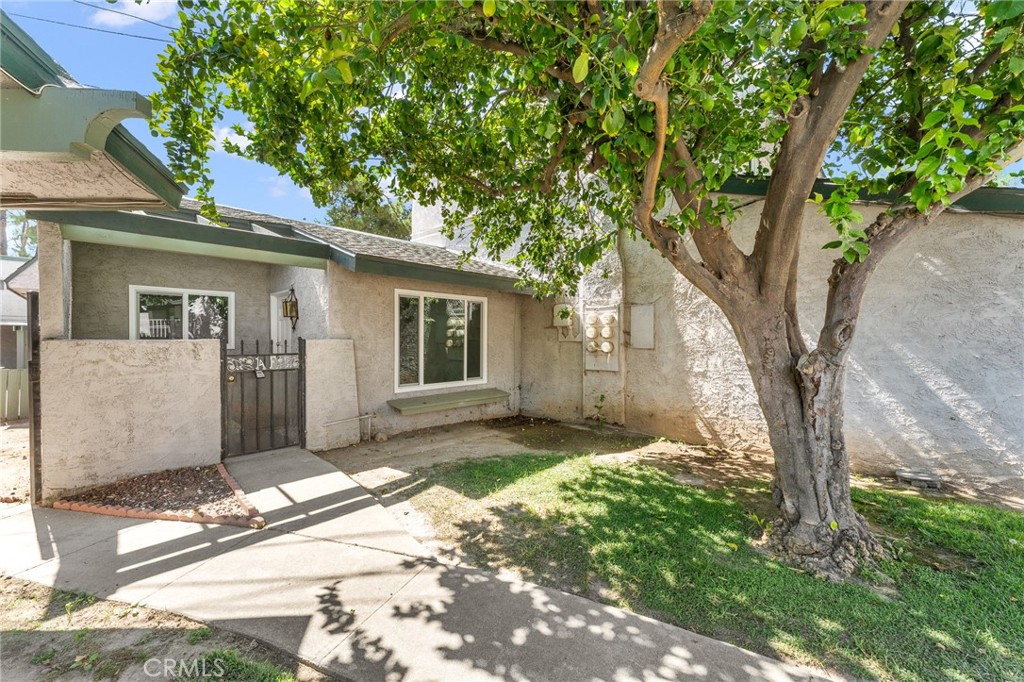a front view of a house with a garden and trees