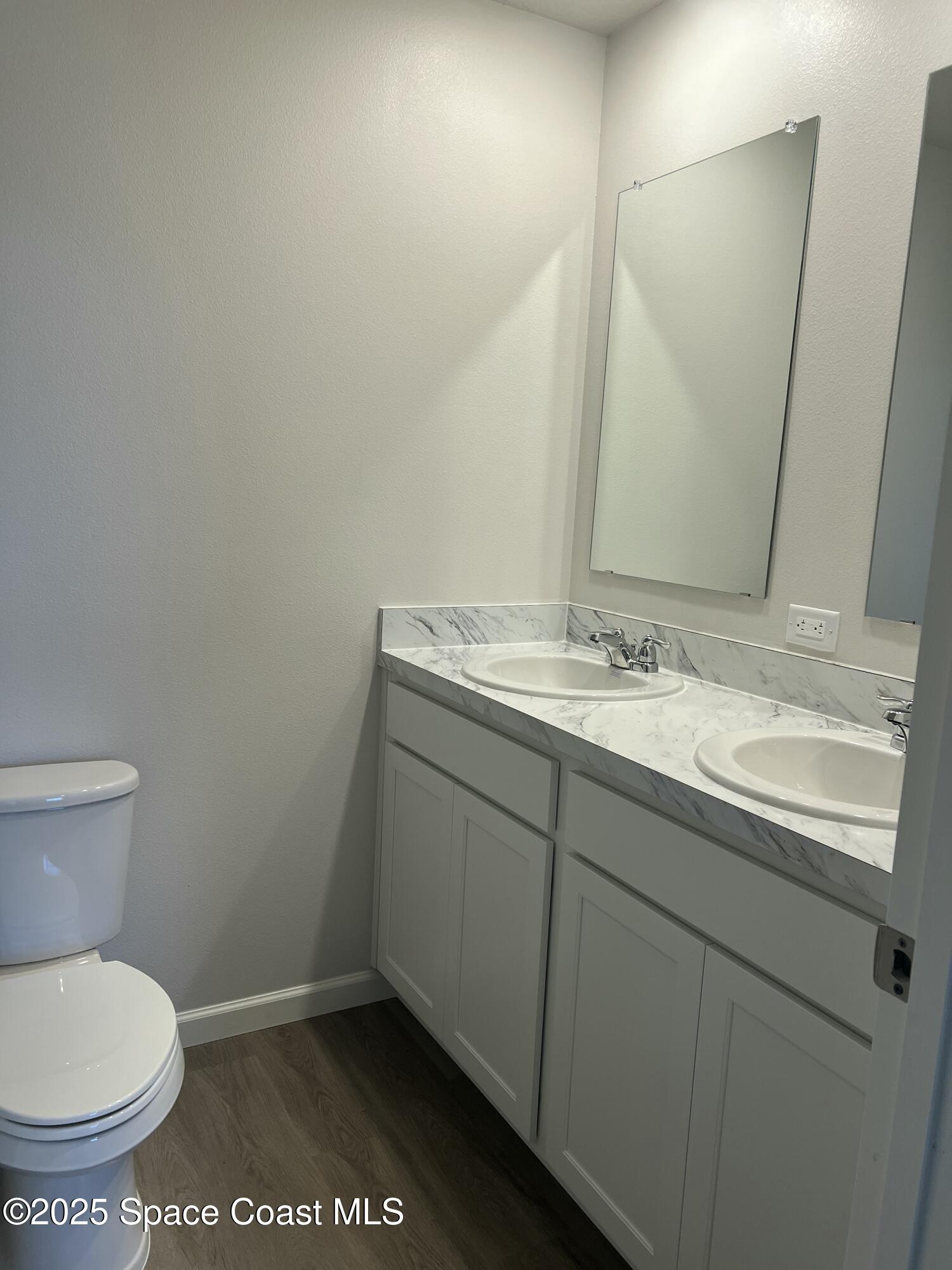 881 Hollahan Road Southeast Palm Bay, FL 32909 - Photo 17 of 21 a bathroom with a granite countertop toilet a sink and a mirror