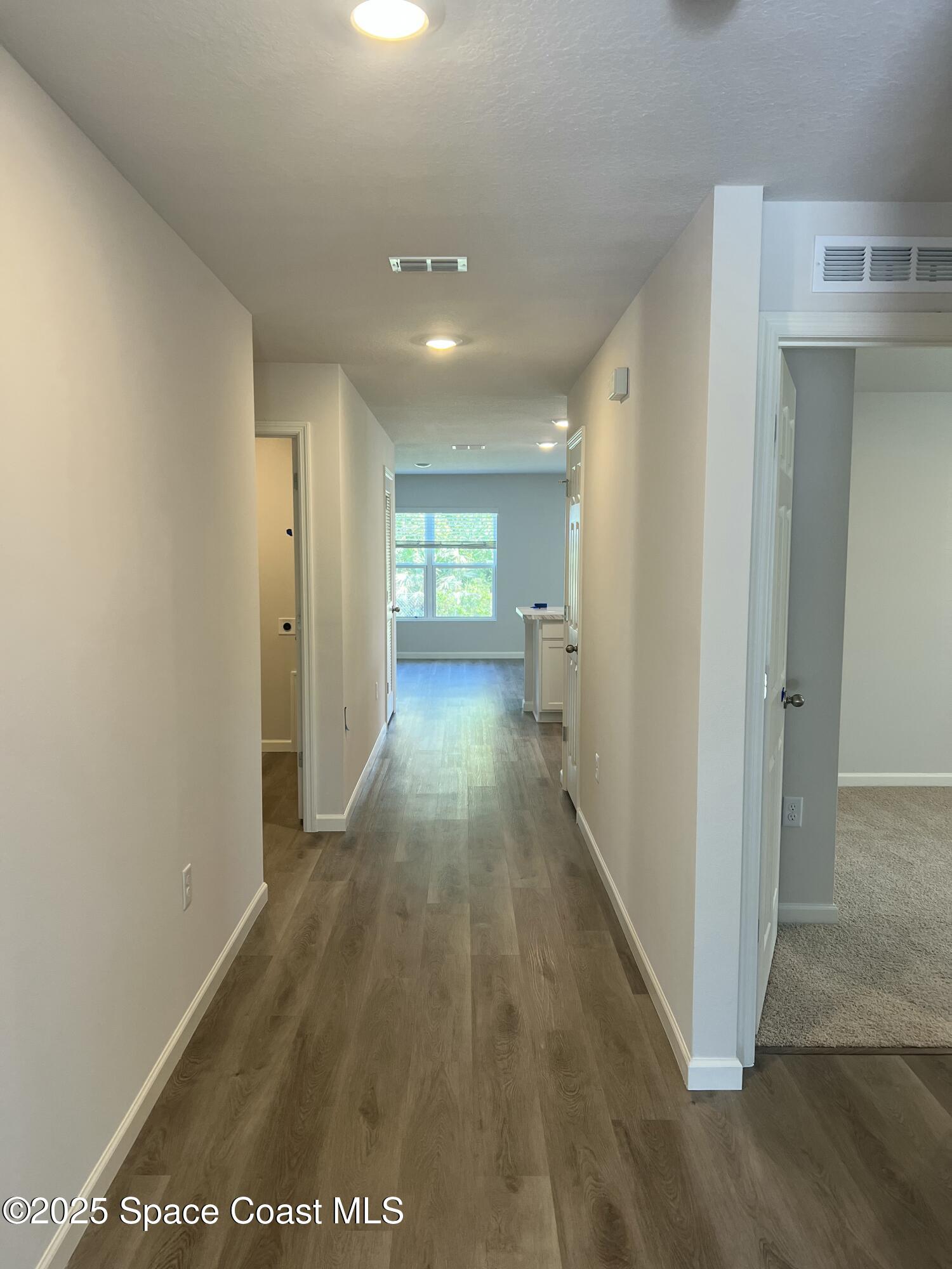 881 Hollahan Road Southeast Palm Bay, FL 32909 - Photo 7 of 21 a view of a hallway with wooden floor and a living room