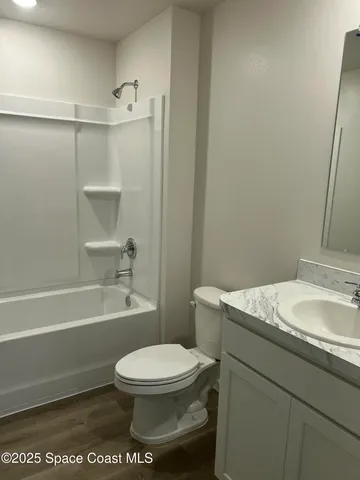 a kitchen with a sink and wooden floor