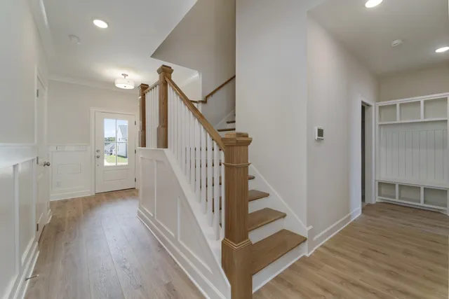 a view of a hallway with wooden floor and stairs