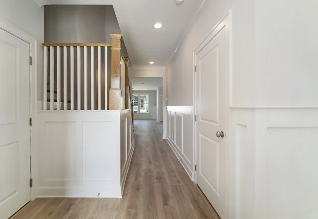 a view of a hallway with wooden floor and staircase