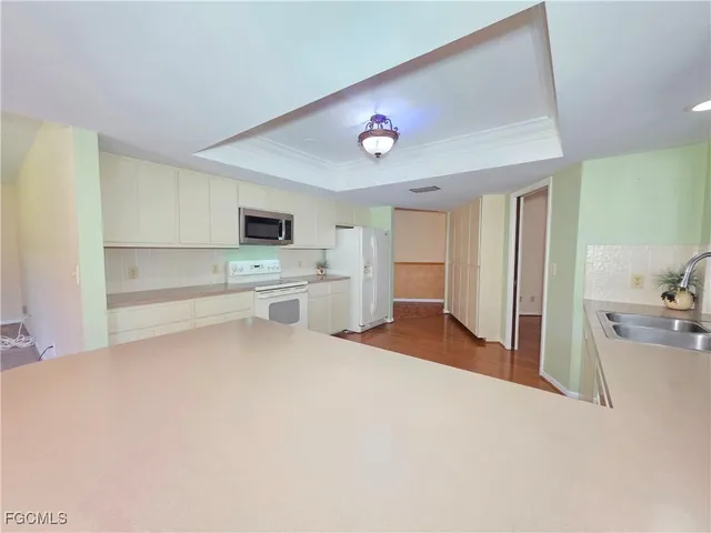 a view of a kitchen with wooden floor and a fireplace