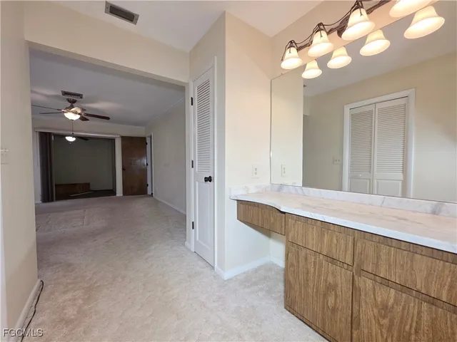 a view of an empty room with a chandelier fan