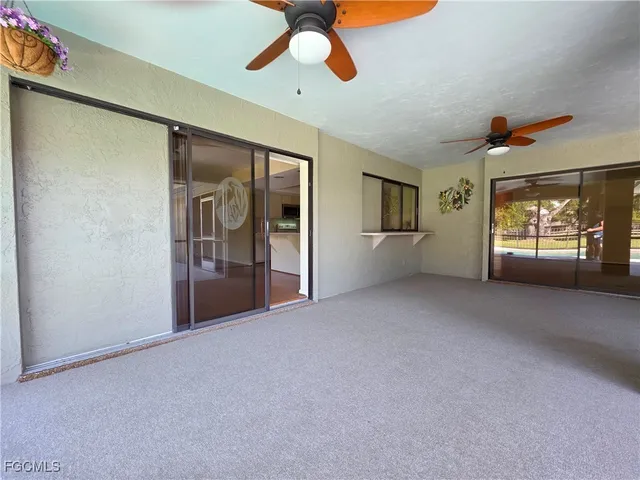 a view of empty room with window and ceiling fan