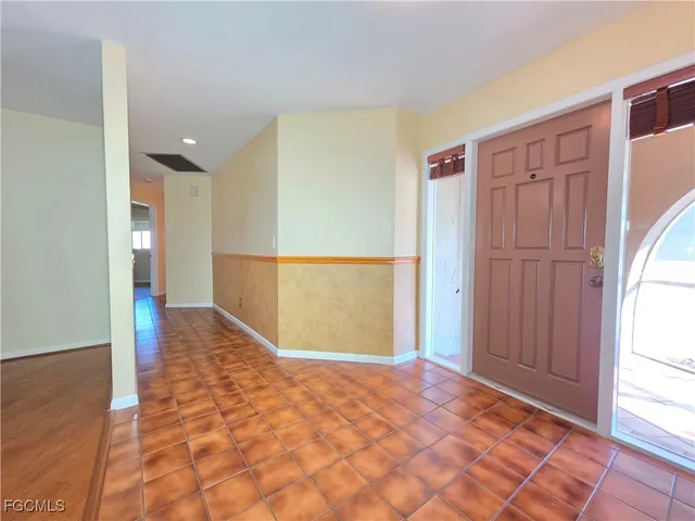 a view of a hallway with wooden floor and cabinet
