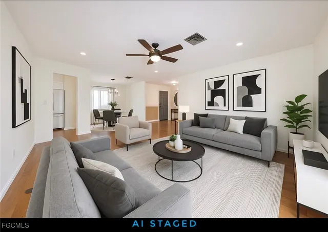 a living room with furniture a rug and a ceiling fan