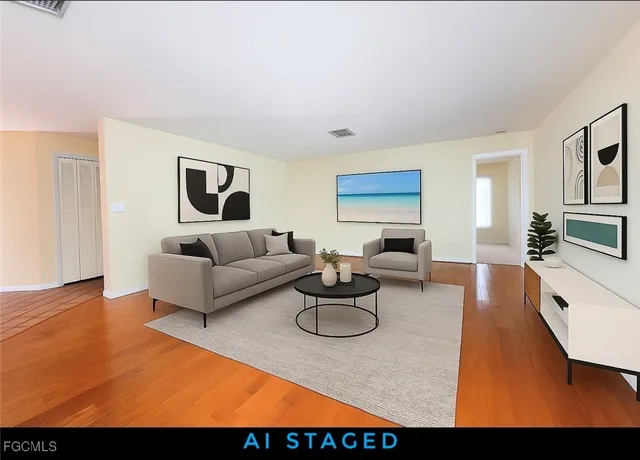 a living room with furniture a flat screen tv and kitchen view