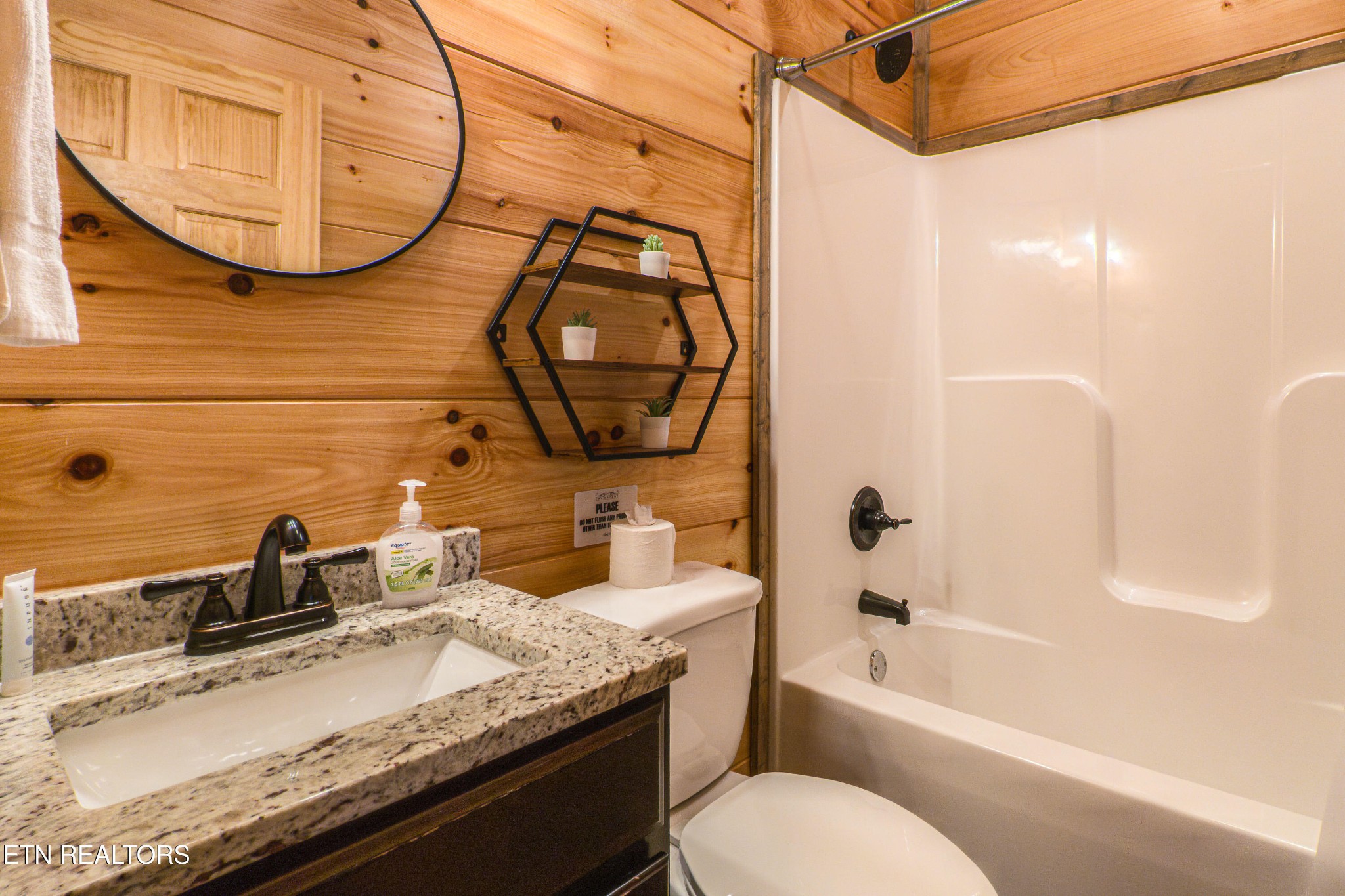 2033 Eagle Feather Drive Sevierville, TN 37876 - Photo 9 of 27 a bathroom with a granite countertop sink a mirror and a shower