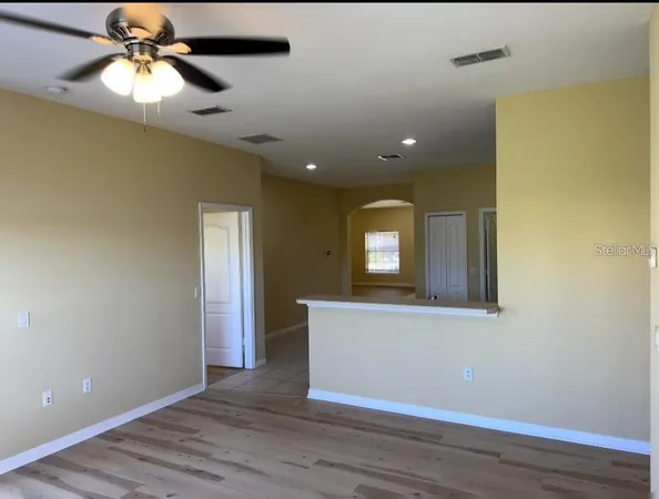 a view of a room with wooden floor and fan