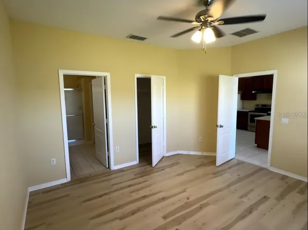 wooden floor in an empty room with a kitchen