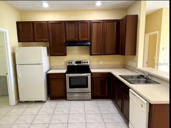 a kitchen with a refrigerator sink and cabinets