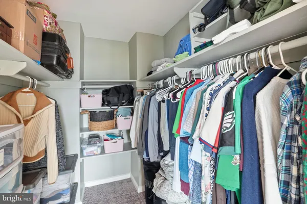 a view of walk in closet with clothes and shoes