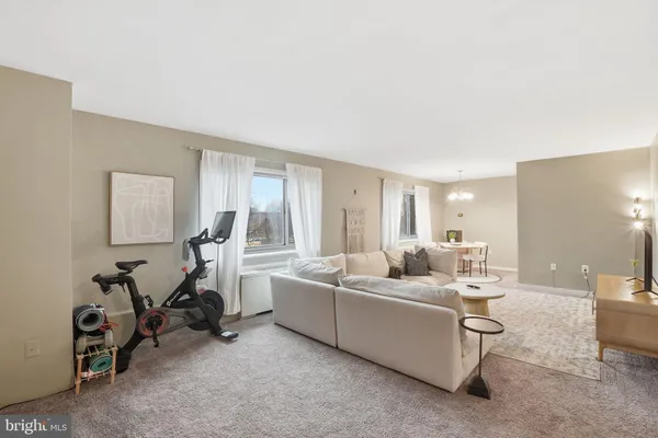 a living room with furniture and a gym machine
